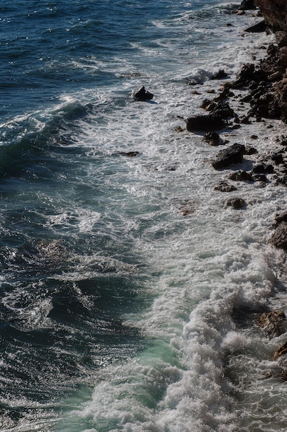 Fond de vague océanique brisant le rivage rocheux de l'eau de mer