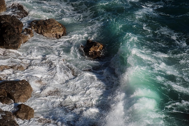 Fond de vague océanique brisant le rivage rocheux de l'eau de mer