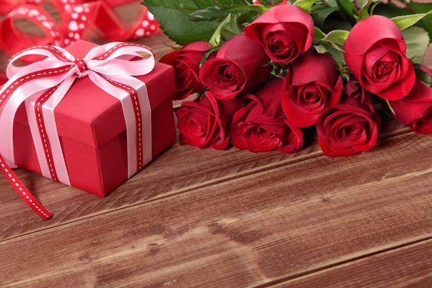 Fond de Valentine de boîte-cadeau et roses rouges sur bois. Espace pour la copie.