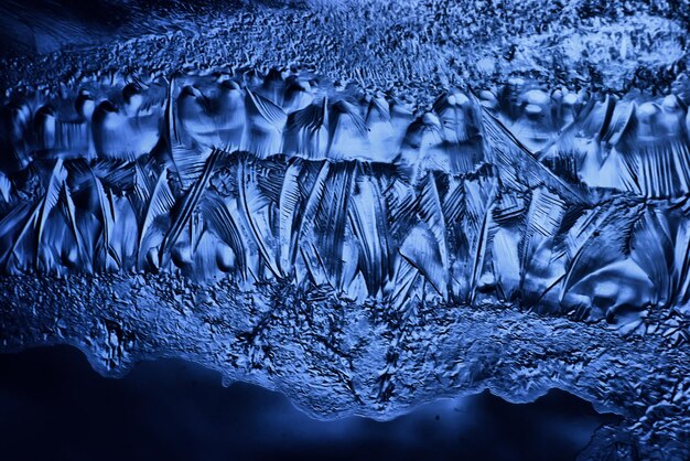 fond de verre de glace bleue, texture abstraite de la surface de la glace sur le verre, eau saisonnière gelée