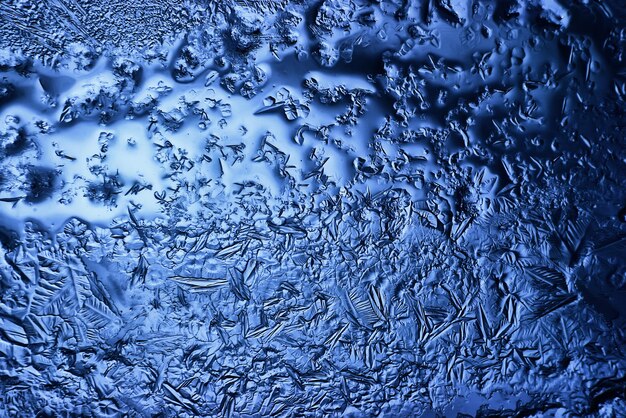 fond de verre de glace bleue, texture abstraite de la surface de la glace sur le verre, eau saisonnière gelée