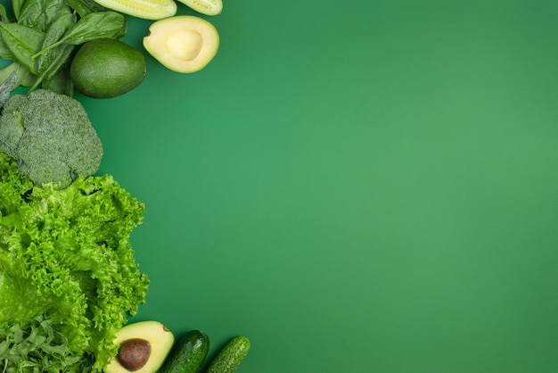 Fond vert avec des légumes et planche de bois