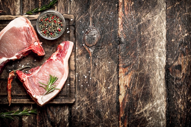 Fond de viande crue. Porc cru aux épices. Sur la vieille table en bois.