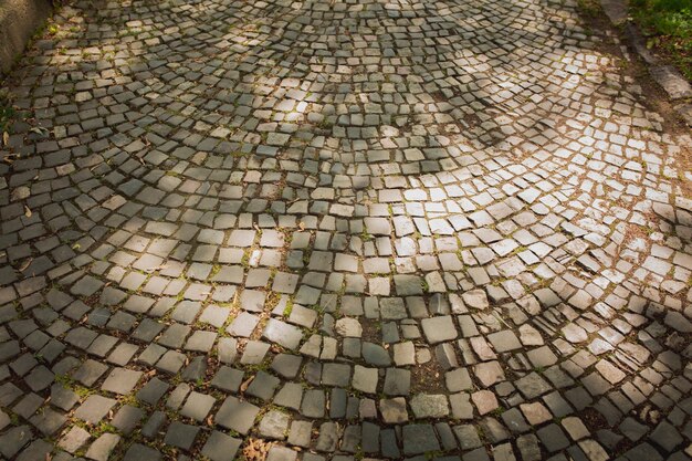 Fond de vieux pavés dans la rue à la lumière du soleil