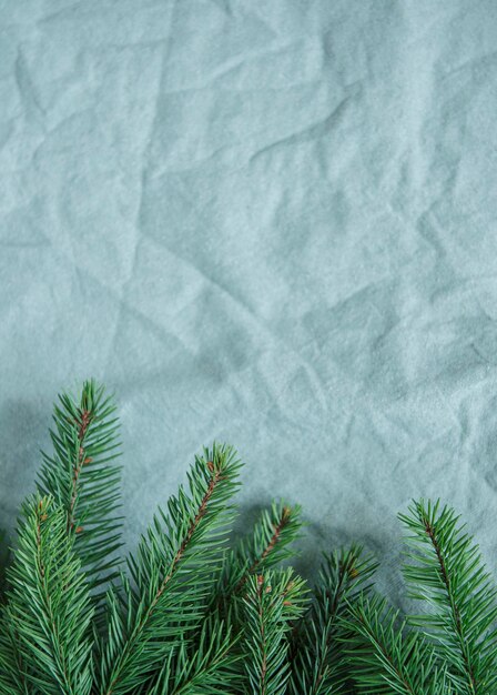 Fond vintage de Noël. Brindilles d'épinette sur le fond textile chiffonné en lin vert