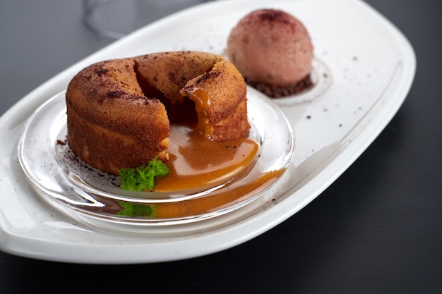 Fondant au caramel sur un plat blanc avec une glace