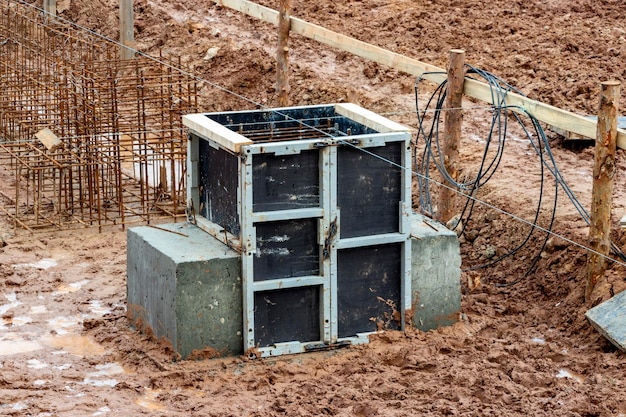 Fondation en béton armé d'un bâtiment résidentiel monolithique moderne Coffrage préparé avec treillis d'armature pour le coulage du béton Saleté et argile sur le chantier