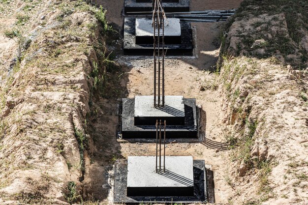 Fondations monolithiques en béton armé pour la construction d'un immeuble résidentiel. Grillage sur le chantier. Fosse de construction avec fondations.