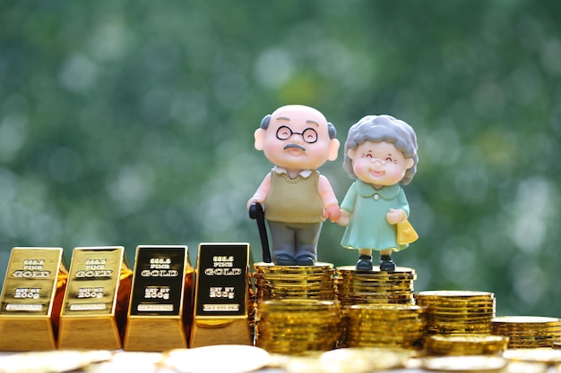 Fonds mutuelAmour couple senior avec de l'argent en pièces d'or et un lingot d'or sur fond vert naturel Économisez de l'argent pour vous préparer à l'avenir et au concept de retraite de retraite