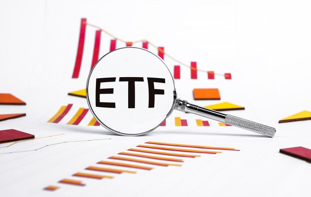 Fonds négocié en bourse Loupe avec texte ETF et graphiques montrant la chute du marché boursier Analyse des risques de récession économique et de crise liés à l'achat ou à la vente d'actions