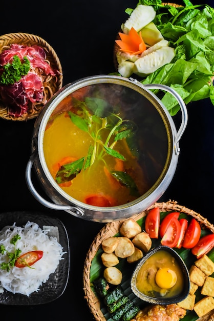 Fondue épicée coréenne avec de la viande de boeuf et des nouilles sur fond noir