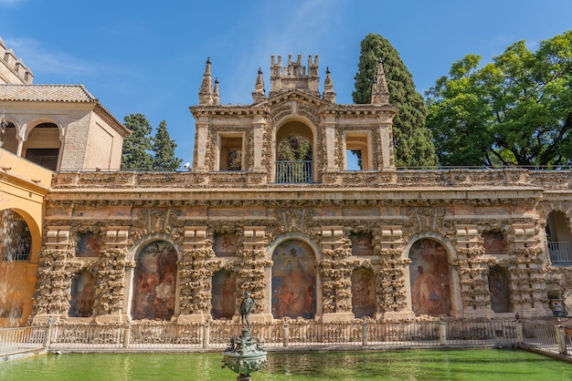 La fontaine avec le bâtiment historique avec la peinture dans la cour du Real Alcazar Palaces à Séville, Andalousie, Espagne