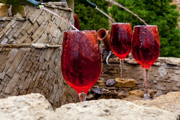 Fontaine avec du vin rouge coulant des bouteilles