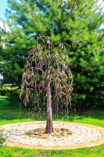 Fontaine en fer forgé en forme d'arbre dans un jardin