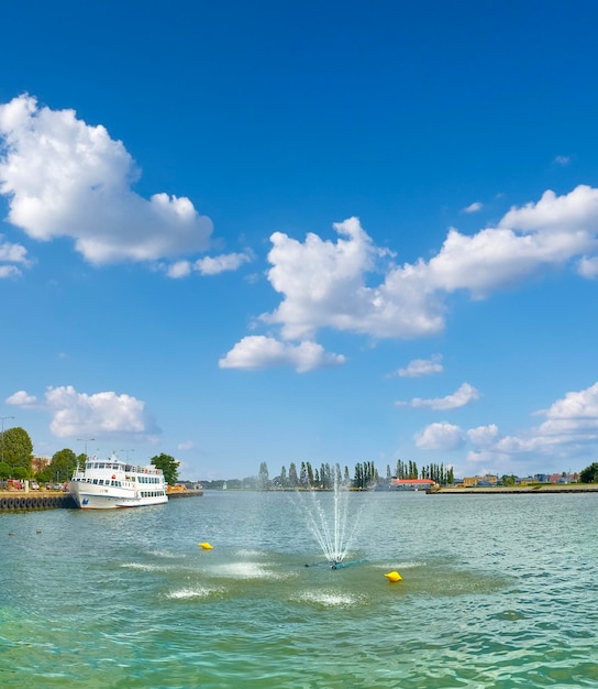 Photo fontaine fluviale et bateau de voyageurs fluvial dans la rivière swina dans la ville de swinoujscie en pologne