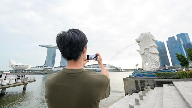 Fontaine Merlion devant la baie de Marina avec un jeune touriste asiatique