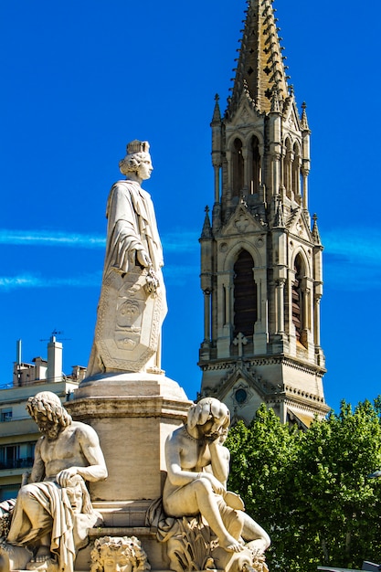 Fontaine Pradier à l'Esplanade Charles-de-Gaulle avec l'église Sainte Perpétue à Nîmes, France