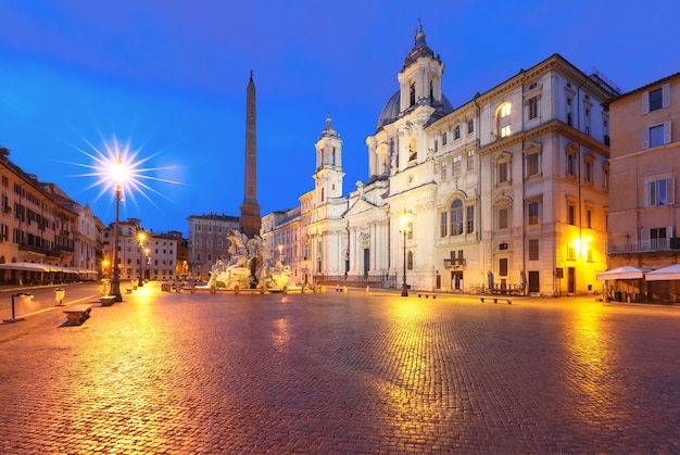 Fontaine des Quatre Fleuves avec un obélisque égyptien et l'église Sant Agnese sur la célèbre Piazza Navona la nuit, Rome, Italie.