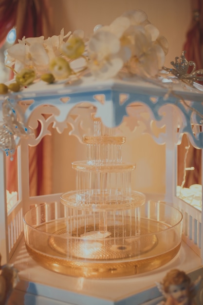 Fontaine de timbre avec lumières et boisson jaune sur la table.