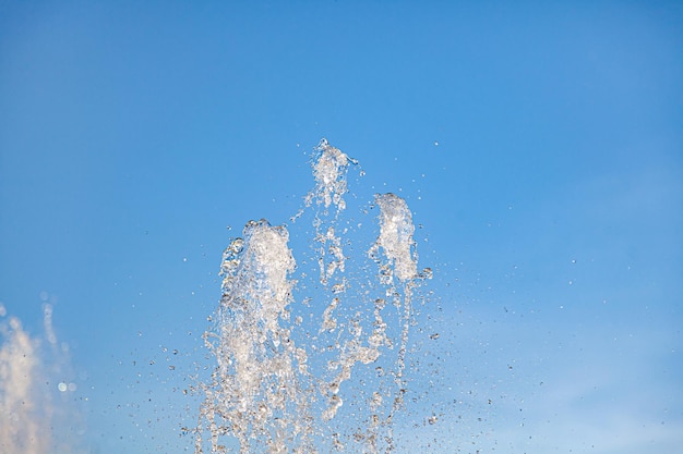 Fontaine de la ville avec éclaboussures et hauts jets d'eau gelés dans l'air par une claire journée d'été contre le ciel bleu clair Fraîcheur et avantages du fluide