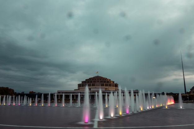 Photo fontaines devant le hall du siècle à wroclaw au coucher du soleil