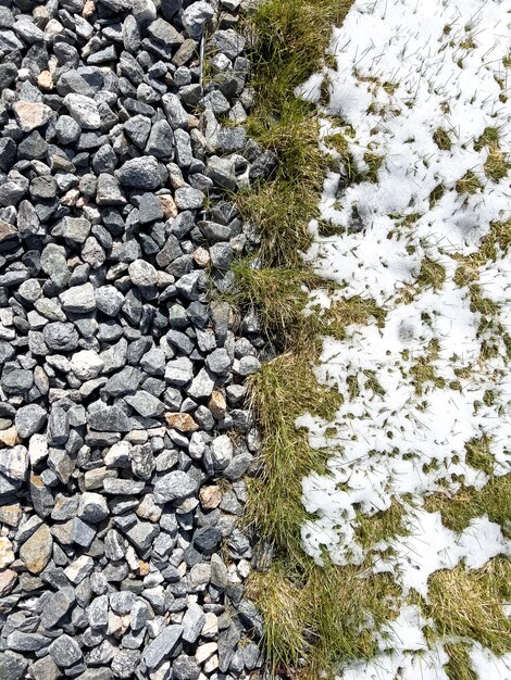 Photo la fonte de la neige au printemps sur le gravier et l'herbe de l'aménagement paysager de banlieue