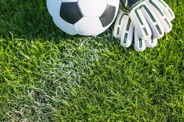 Photo football dans l'herbe avec des gants