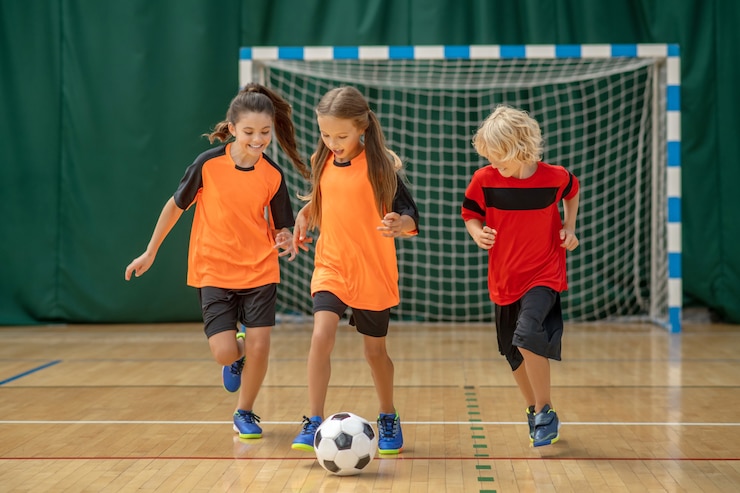 Football. Enfants en tenue de sport courir après le ballon