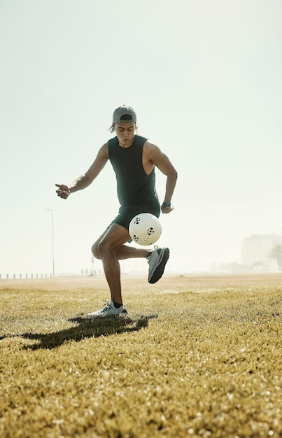 Photo football sportif et homme qui court sur le terrain de football en plein air entraînement aux objectifs de remise en forme pour la compétition sportive motivation d'entraînement cardio de jeune athlète et développement d'exercices sains pour l'énergie ou le bien-être