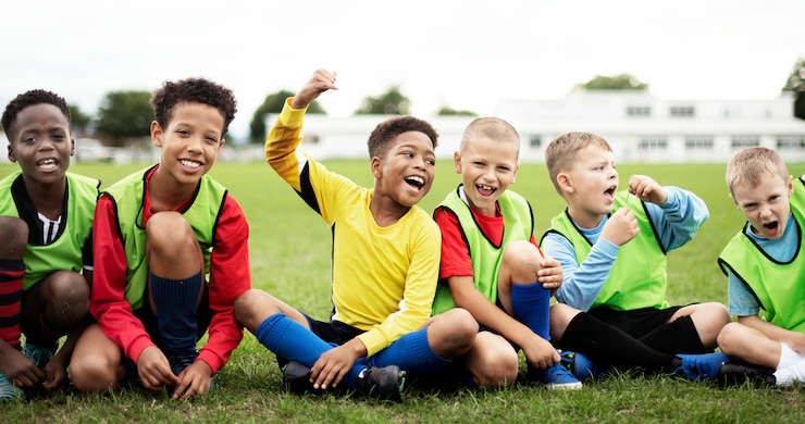 Photo footballeurs enthousiastes assis sur le terrain