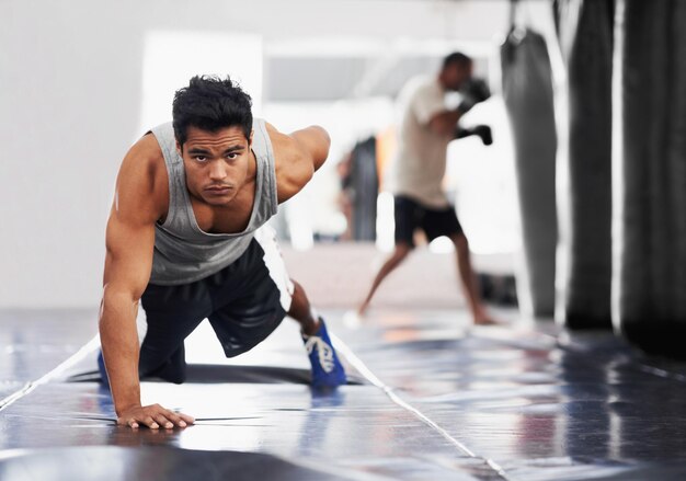 Force féroce pure Portrait d'un jeune boxeur concentré faisant des pompes dans la salle de gym