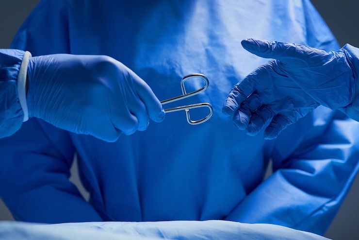 Photo forceps s'il vous plaît gros plan d'un groupe de chirurgiens travaillant sur un patient dans une salle d'opération