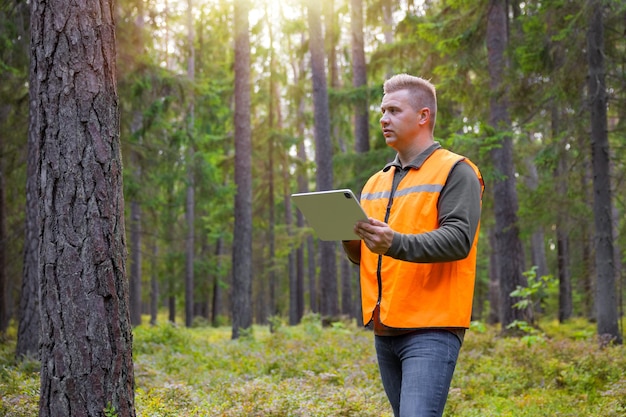 Forestier travaillant et utilisant une tablette en forêt