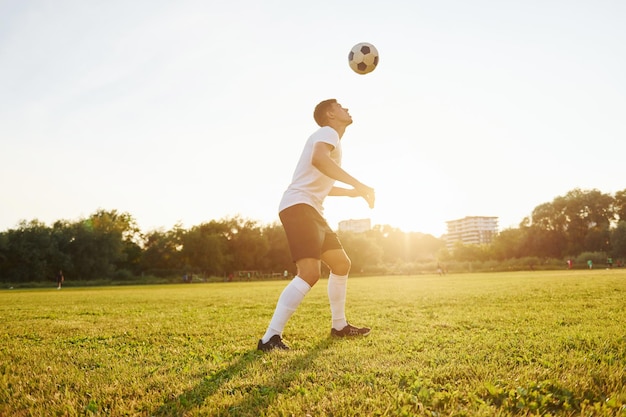 Forêt sur fond Jeune footballeur s'entraîne sur le terrain sportif