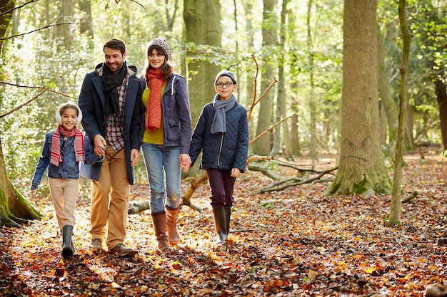 Photo forêts de hêtres en automne famille en manteaux chauds marchant main dans la main