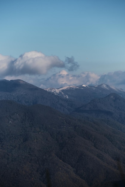 Les forêts de montagne et les pics de rochers dans la neige peuvent être vus à l'horizon à distance
