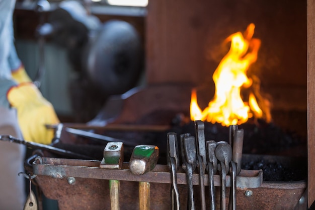 Un forgeron travaillant dans une ancienne forge de fer.