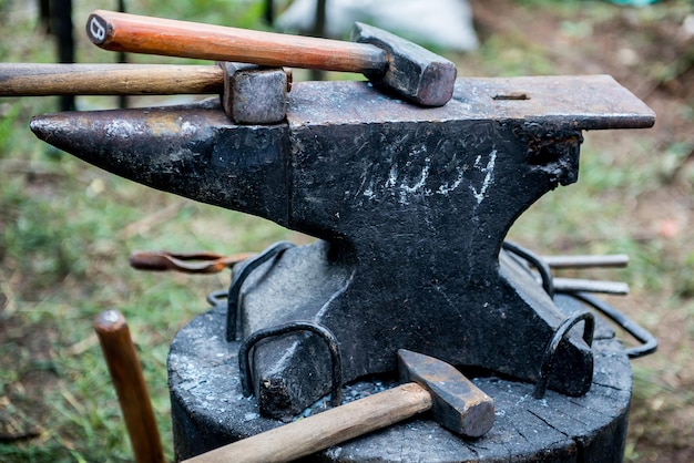 forgeron travaille sur une enclume. Maître forge produit. Outils et enclume de forgeron. Forgeron travaillant à l'extérieur.