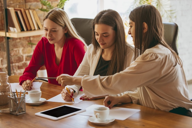 Formalités administratives. Jeune femme d'affaires dans un bureau moderne avec équipe. Réunion créative, attribution de tâches. Les femmes travaillant au front-office. Concept de finance, d'affaires, de pouvoir des filles, d'inclusion, de diversité, de féminisme.