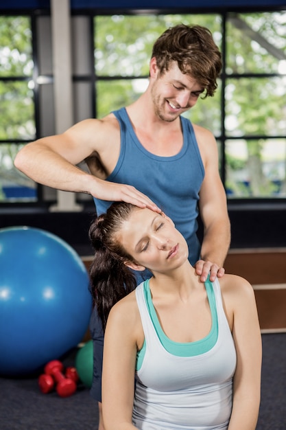 Formateur aidant la femme avec l'exercice du cou