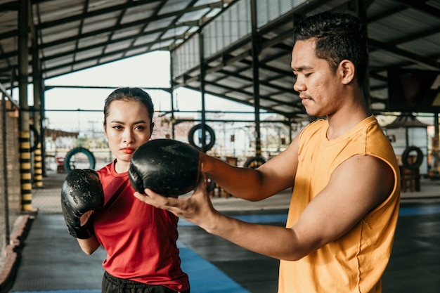 Formateur avec une femme boxer debout ensemble pendant une formation