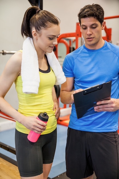 Photo formateur et femme discutant d'un plan d'entraînement