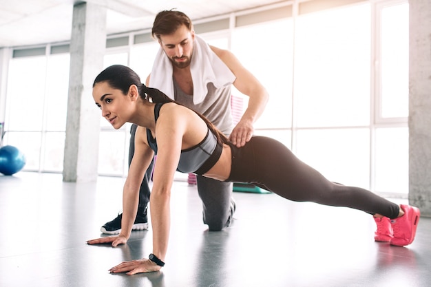 Le formateur et son élève sont dans une salle de fitness