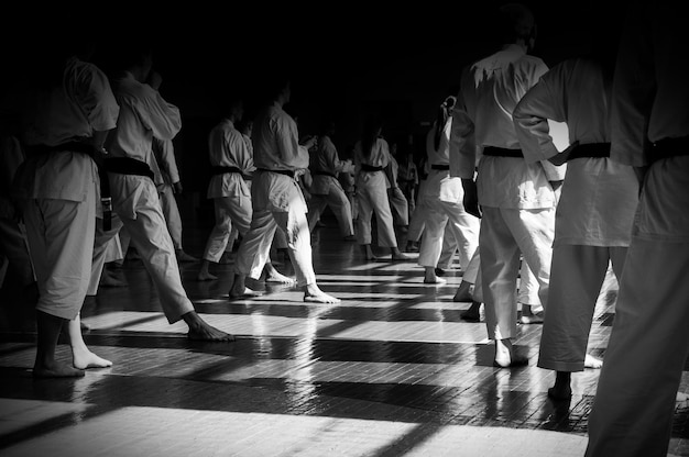 Photo formation sur karatedo image d'arrière-plan avec espace pour le texte tous dans la même forme et les visages sont cachés dans l'obscurité ce qui rend les gens identiques au-delà de la reconnaissance pour les pages web ou l'impression publicitaire