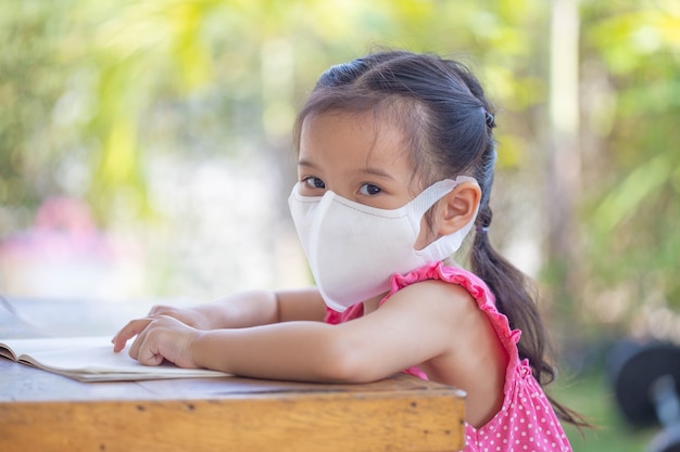 Formation En Ligne à Distance. Enfant Dans Un Masque Pour Regarder Une Leçon En Ligne.