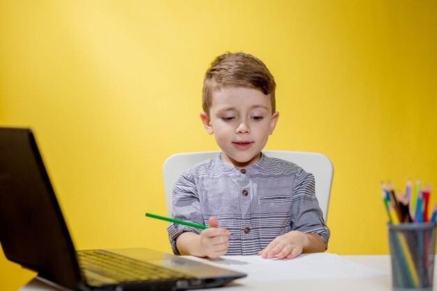 Formation en ligne à distance. Un garçon s'installe à la maison et fait ses devoirs scolaires, met en quarantaine l'apprentissage à distance à domicile.