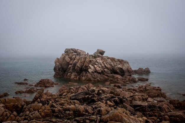 Photo formation rocheuse en mer contre un ciel dégagé