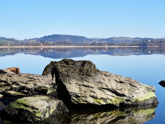 Formation rocheuse par le lac contre un ciel bleu clair