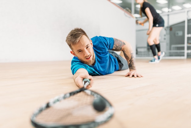 Formation de squash, joueur masculin avec raquette se trouve sur le sol.