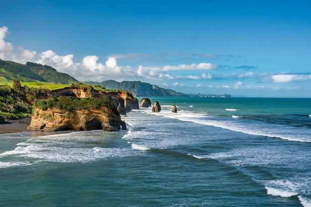 Les formations rocheuses connues sous le nom de Les trois sœurs à la plage de Tongaporutu à marée haute sur la coa de Taranaki